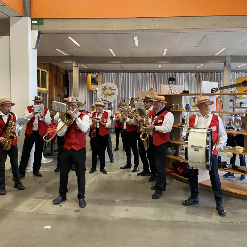 Een fanfare speelt tussen de rekken van de Kringwinkel.