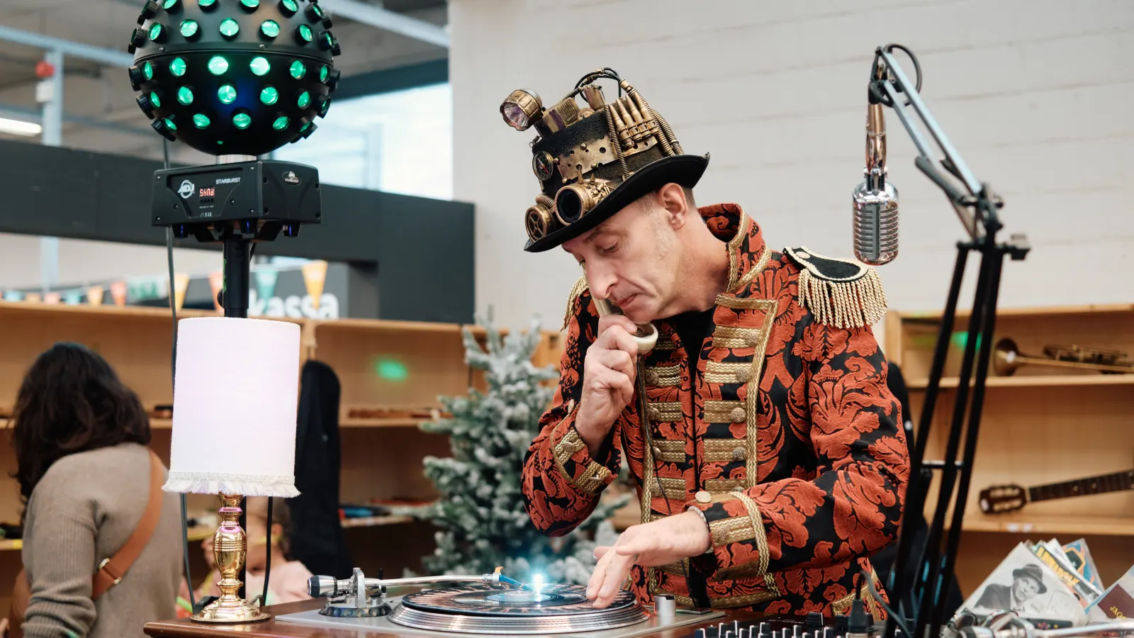 Een dj draait platen tussen de rekken tijdens Dag van de Kringwinkel.