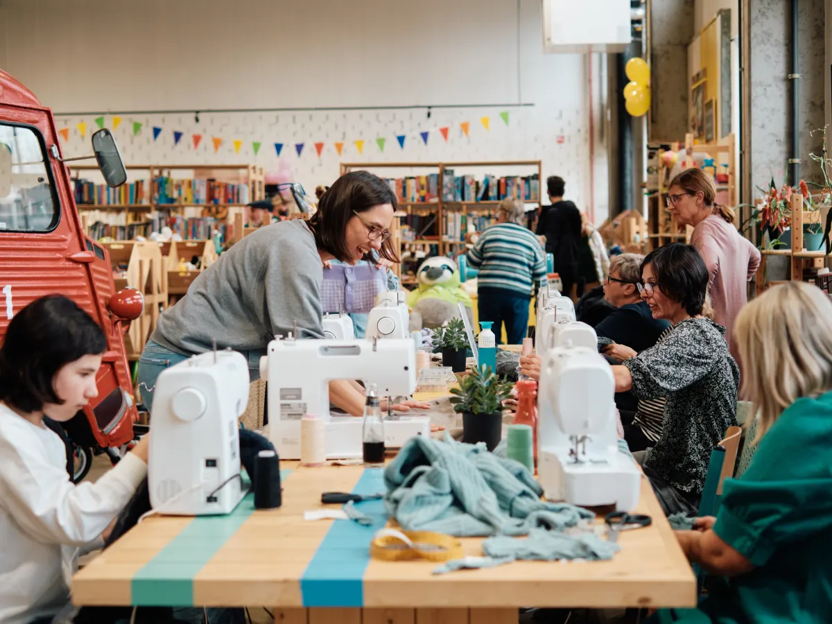 Medewerkers aan het werk aan de naaimachines in het naaiatelier.