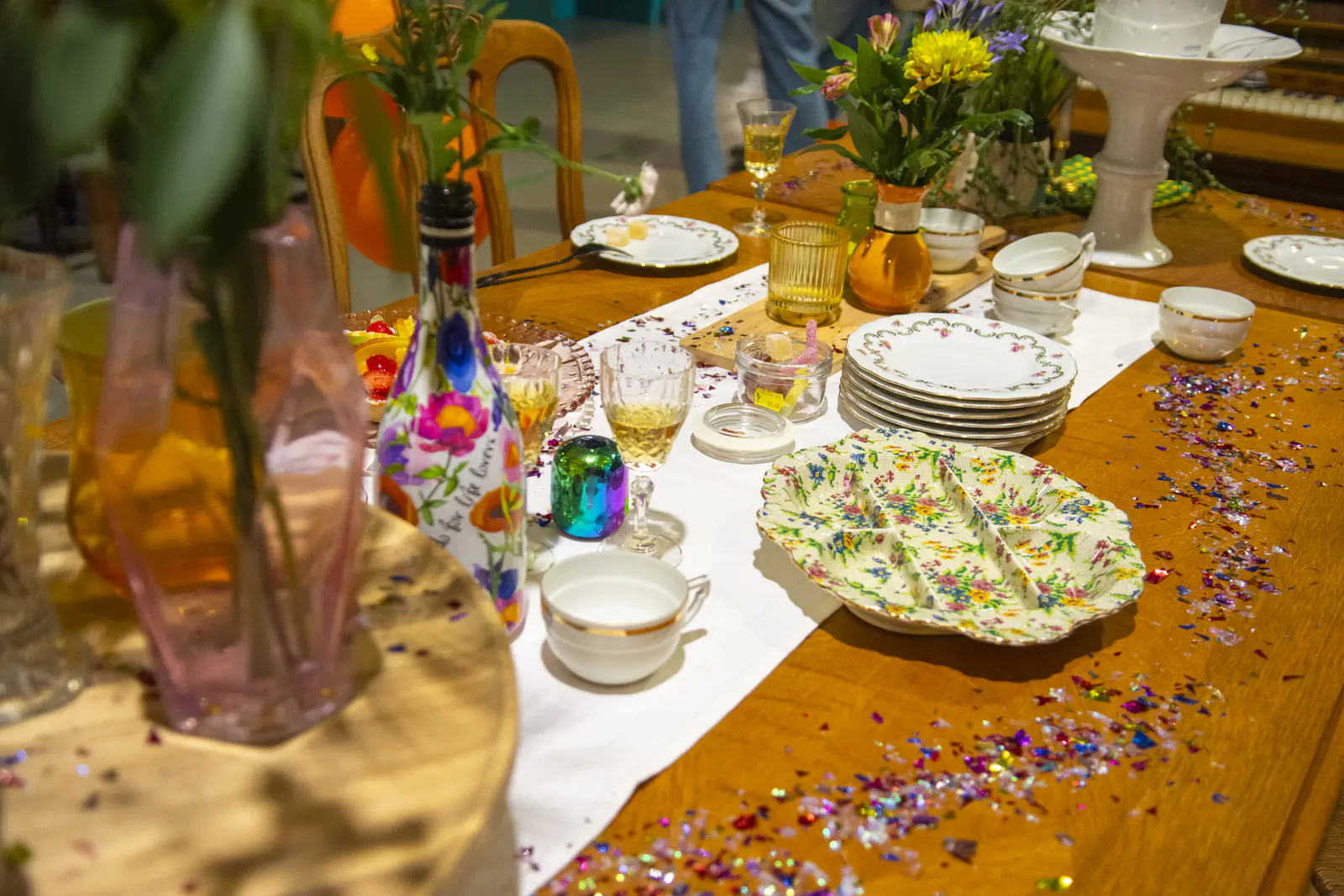 Een feestelijk gedekte tafel vol tweedehands servies, bloemen en confetti in de Kringwinkel.